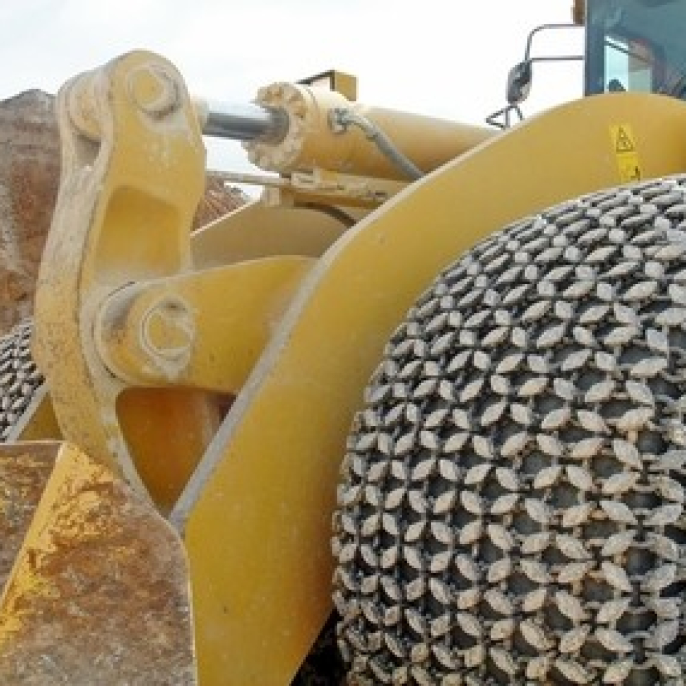 Heavy machinery with traction chains on the tires, working in a quarry.