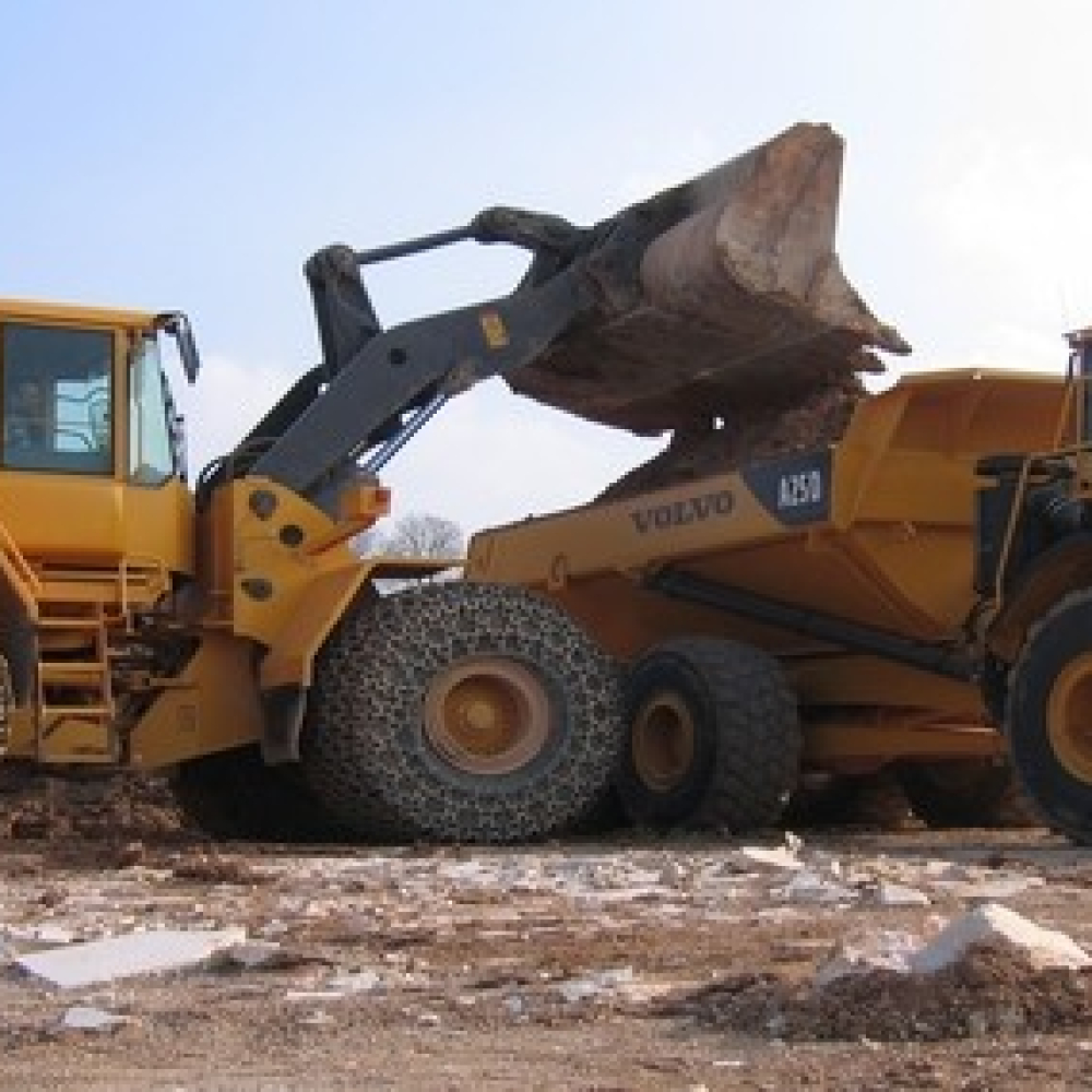 Two Volvo wheel loaders working on a construction site, with heavy equipment operations.