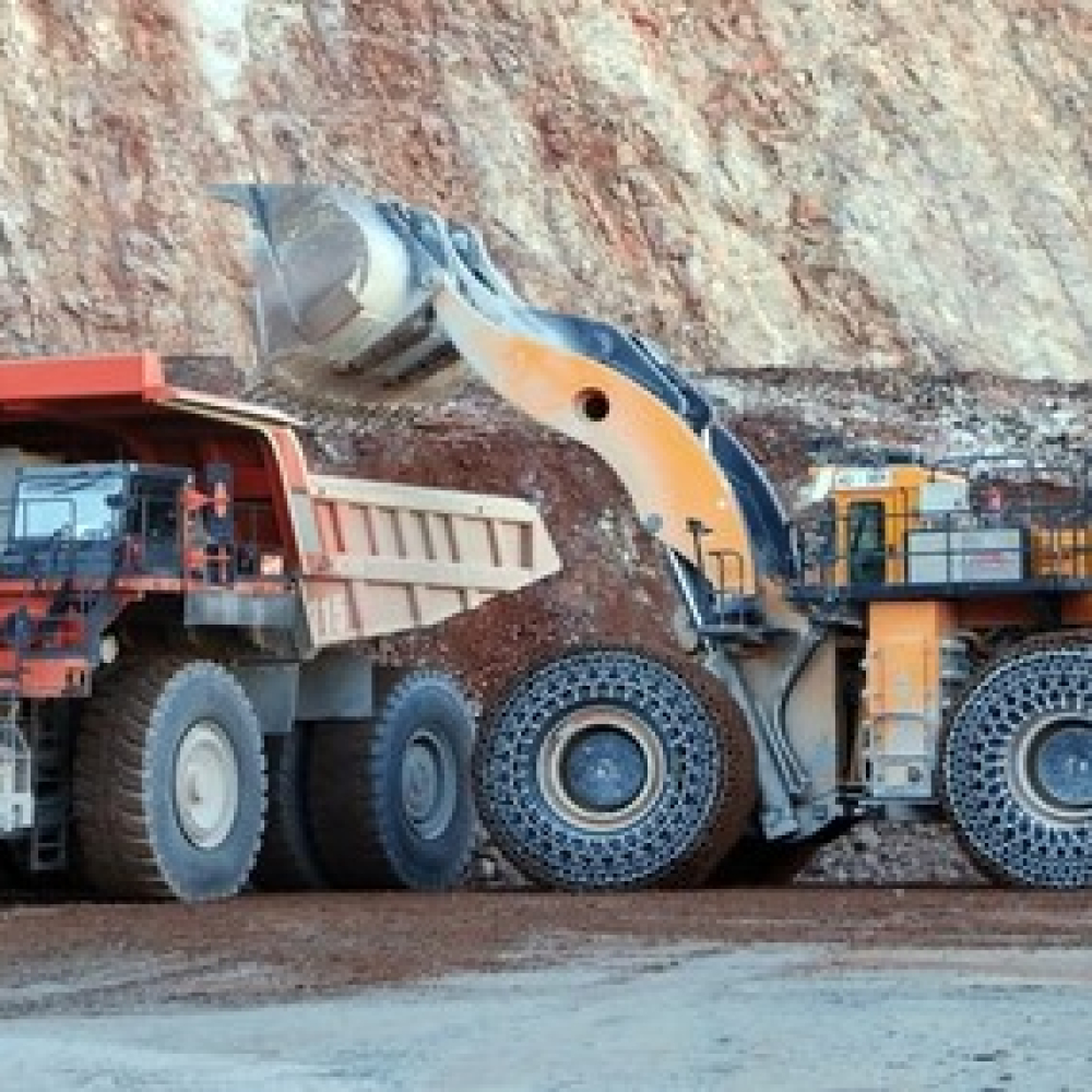 Heavy machinery in operation with traction chains on large articulated trucks.