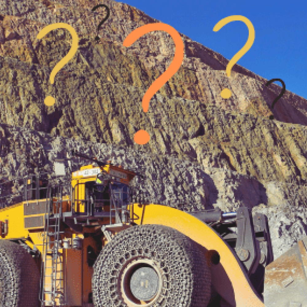 Heavy machinery on a mining site, showcasing large tires and rugged terrain.