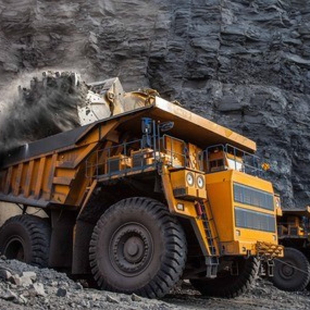 Large haul trucks operating in a mining site, transporting extracted materials.
