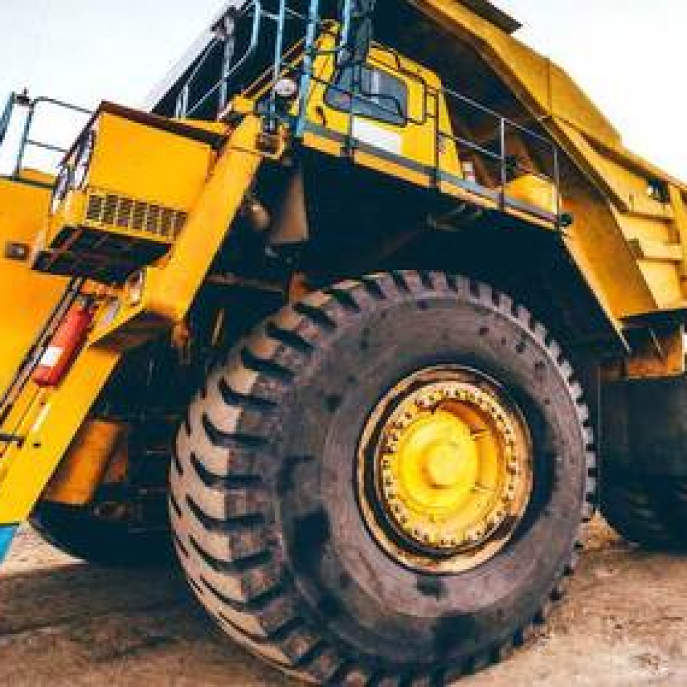 Heavy-duty dump truck with large tires at a construction site.