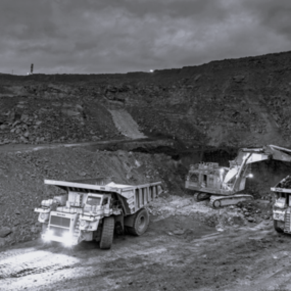Heavy machinery in operation at a mining site, including dump trucks and excavators.